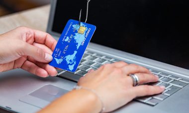 Credit card phishing. Phishing scam with credit card in fishing hook. Woman typing her credit card information on scam site